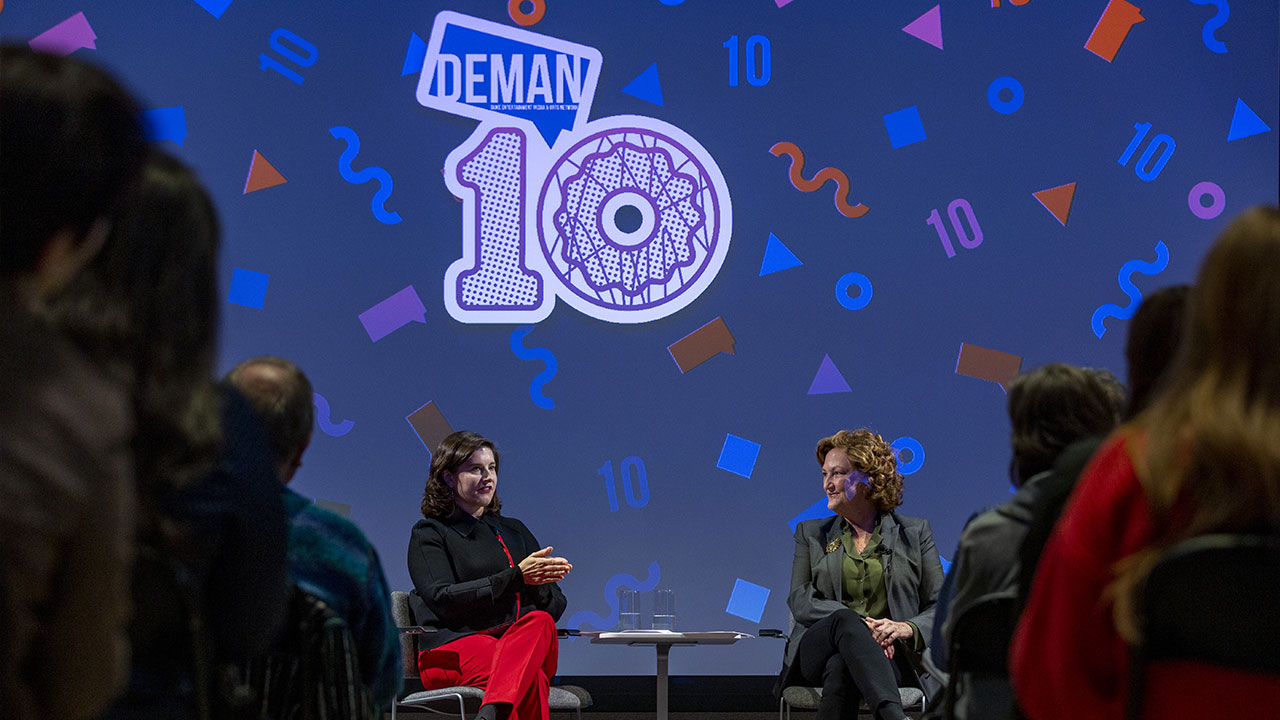 A photo of two people on stage at DEMAN Weekend