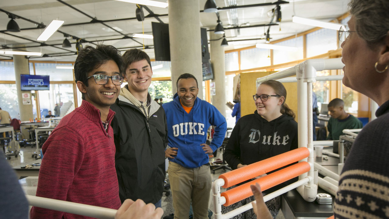 A group of students discussing a project with their instructor in Duke’s Design POD